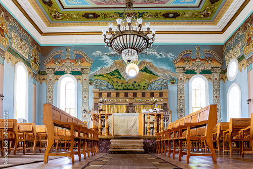 Kutaisi Synagogue inside view of nave and altar with wooden benches and richly decorated walls with colorful paintings, Georgia photo