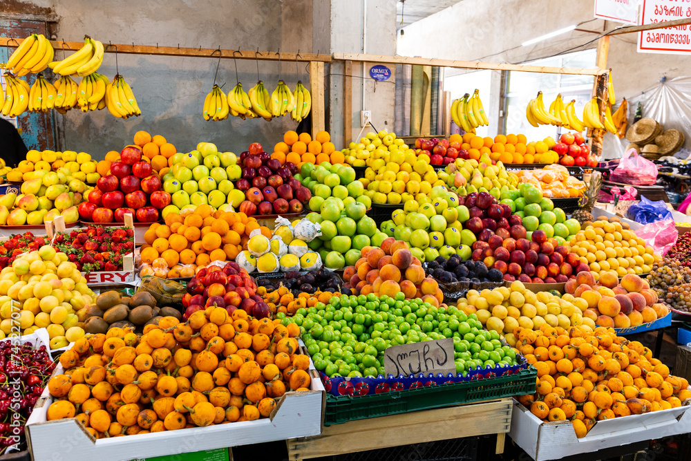 Market stall with colorful local fruits in Kutaisi Central Market (Green Bazaar,  Mtsvane Bazari) hall, Georgia.