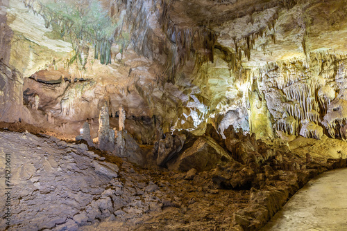 Prometheus Cave Natural Monument - largest cave in Georgia with hanging stone curtains, stalactites and stalagmites, colorful illuminated rock formations and tourist path.