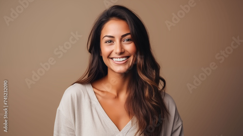 Close up of young woman with white skin  brown long hair  wavy hair and a clear white t shirt  isolated in a light orange studio. Portrait person.