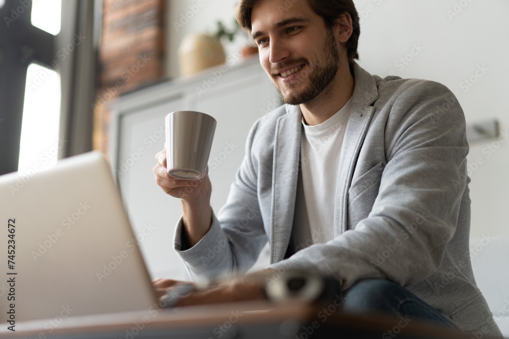 Businessman working with laptop from home sitting at table. Businessman working with laptop from home sitting at table.