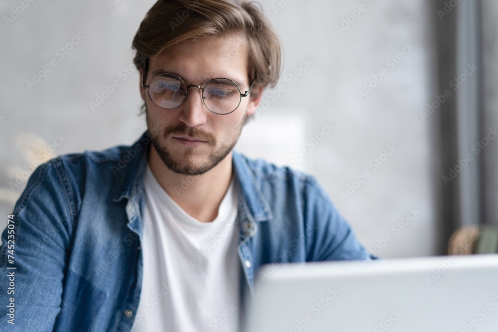 Businessman working with laptop from home sitting at table. Businessman working with laptop from home sitting at table.