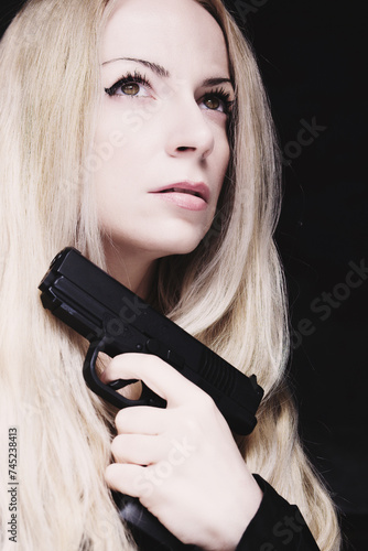 A beautiful woman holding a gun