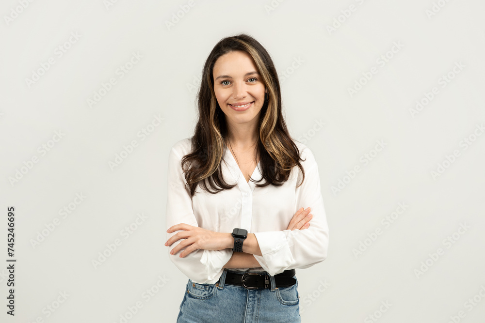 Professional young woman with a friendly smile, standing with arms crossed Professional young woman with a friendly smile, standing with arms crossed