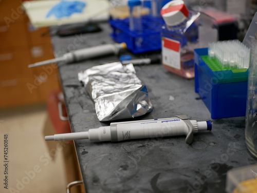 Pipette and some working instruments under a biological laboratory bench