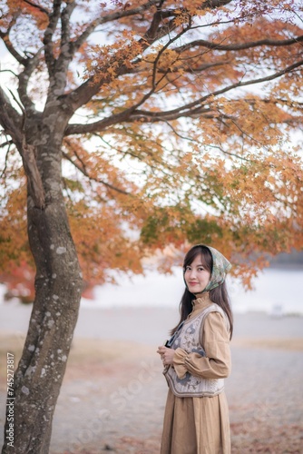 Casual dress charm: Asian woman in Japan's fall beauty, a cheerful holiday portrait in yellow and red foliage. A journey capturing the essence of nature, fashion, and casual elegance.