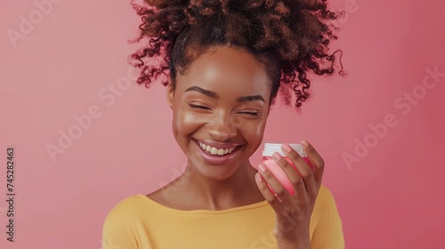 afro american girl holding a cream for skincare wellness that brings out natural shine in a studio