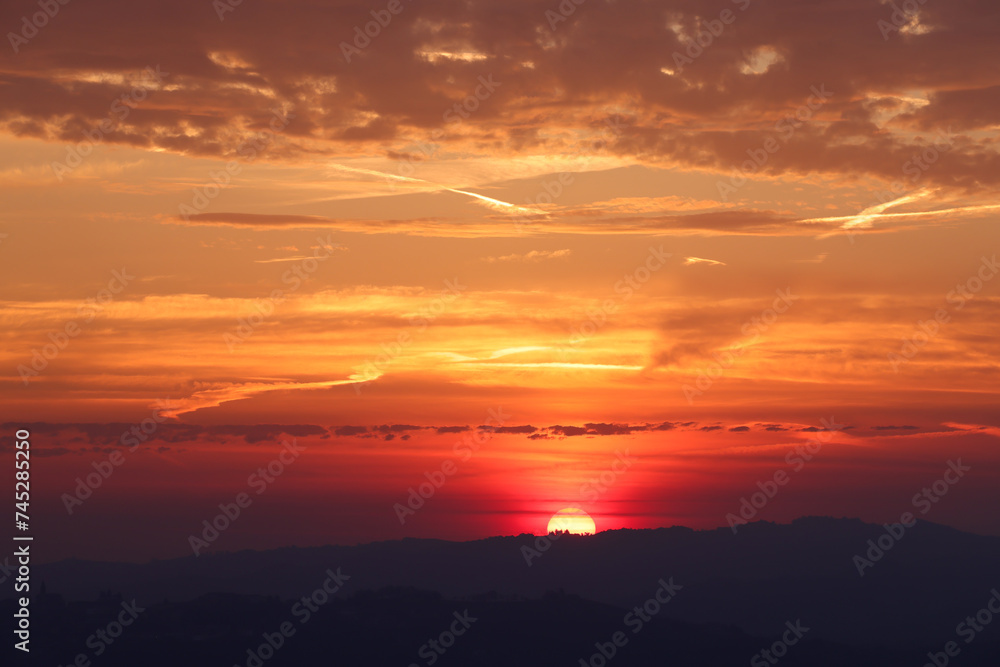 the sun rises behind a mountain range in Piedmont the sun rises behind a mountain range in Piedmont