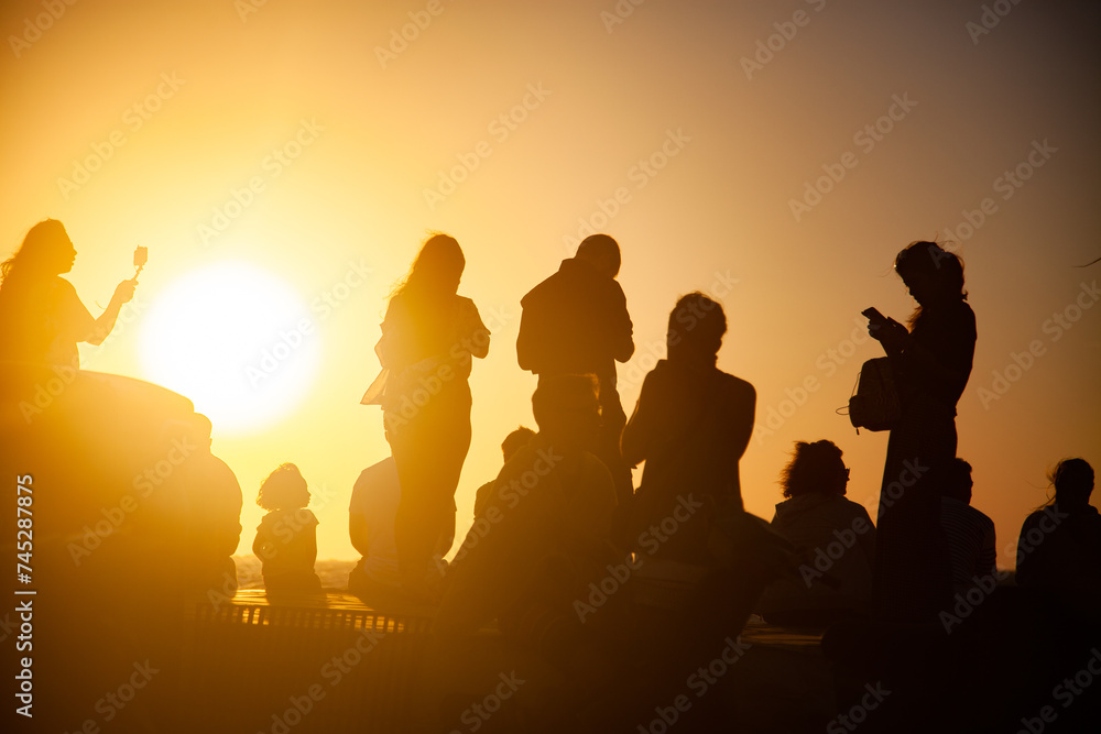 silhouettes of people watching the sunset