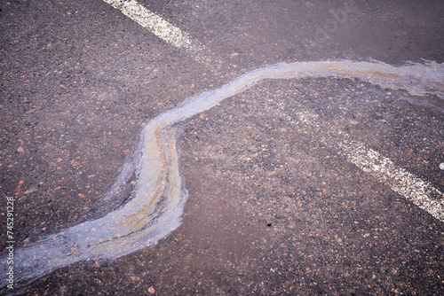 Obraz na plátně Oil, gasoline, or oil spill on wet asphalt with a parking lot and a dividing line
