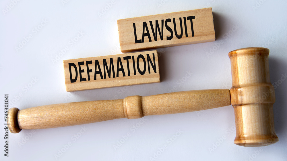 DEFAMATION LAWSUIT - words on wooden blocks on a white background with a judge's gavel. DEFAMATION LAWSUIT - words on wooden blocks on a white background with a judge's gavel.