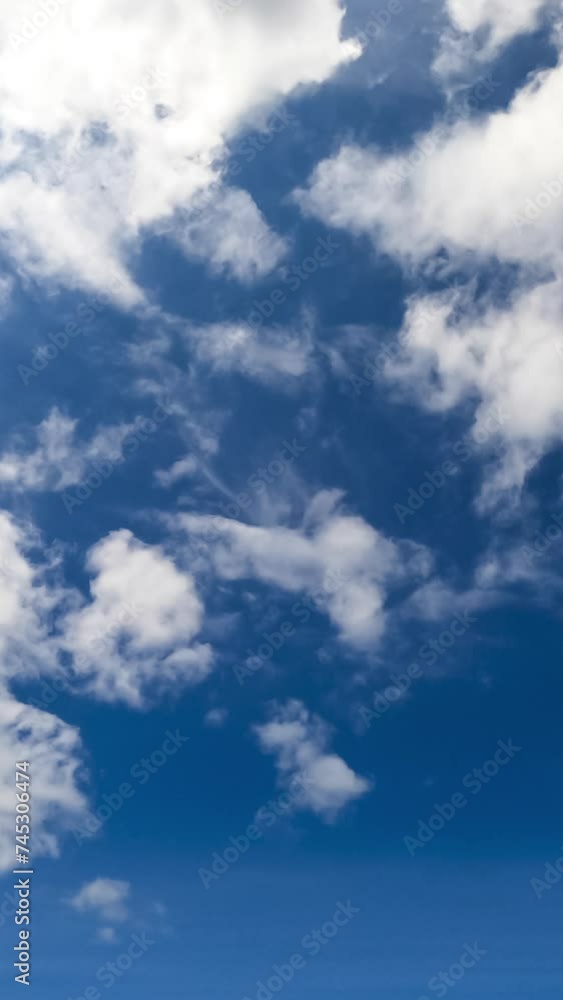 Ethereal white fluffy clouds moving by the sky. Sunny summer day sky timelapse. Low angle view. Vertical video. Ethereal white fluffy clouds moving by the sky. Sunny summer day sky timelapse. Low angle view. Vertical video.