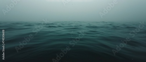 a large body of water that has some water droplets on the surface of the water and the sky in the background.