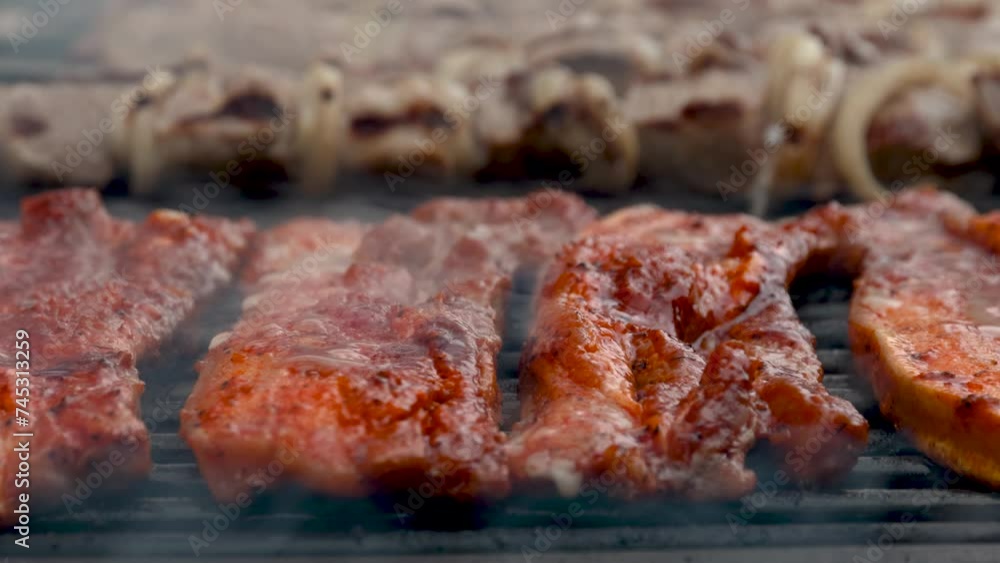 Food preparation process of marinated and spiced pork fillet meat cooked on charcoal barbeque grill. Outdoors cooking. Food preparation process of marinated and spiced pork fillet meat cooked on charcoal barbeque grill. Outdoors cooking.