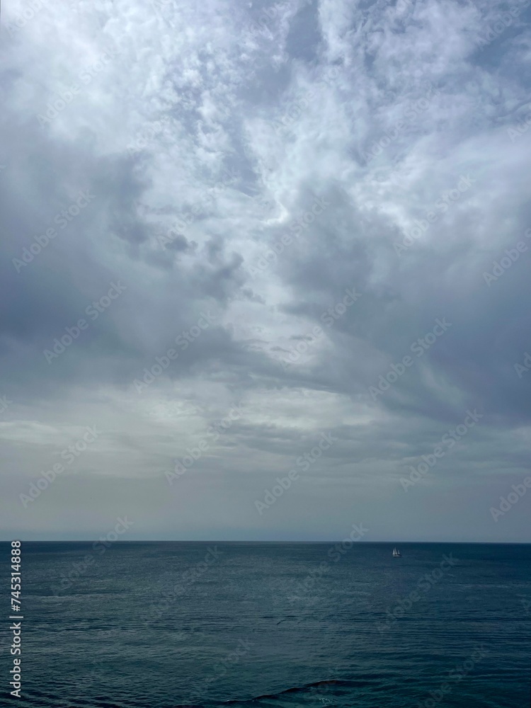 Cloudy seascape, sail boats silhouettes at the sea Cloudy seascape, sail boats silhouettes at the sea