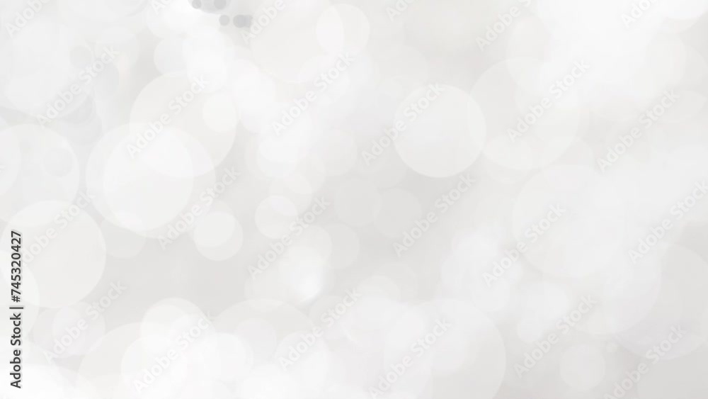 Abstract video background with glowing and randomly moving bokeh white light rings. Abstract motion loop white background.