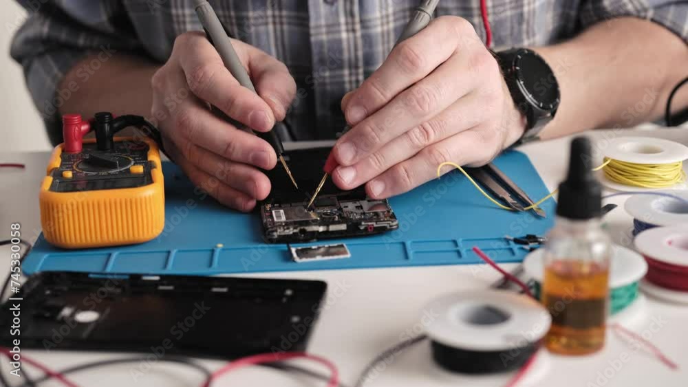Master Fixing Microchip Of Broken Smartphone, Using Digital Multimeter In Service Center Master Fixing Microchip Of Broken Smartphone, Using Digital Multimeter In Service Center