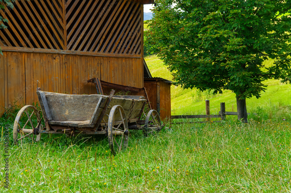 an old carriage near the farm building. country landscape