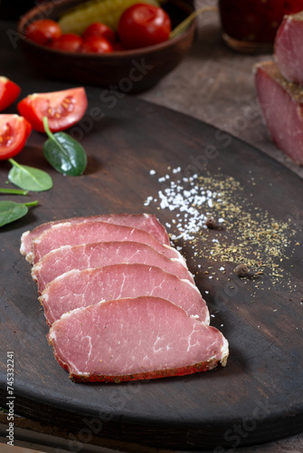 Meat dried pork ham cut into strips among vegetables and herbs