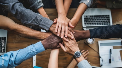Diverse team building: multicultural members join hands in unity, emphasizing workplace collaboration and inclusivity photo