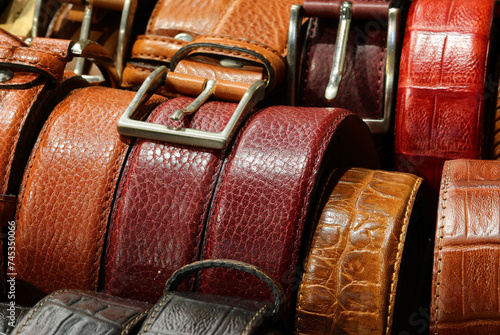 Leather belts handcrafted with metal buckles are available for purchase at the leather goods store photo