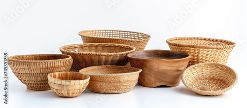 A collection of empty wicker bowls and baskets are arranged neatly next to each other on a white background, showcasing traditional handmade items.