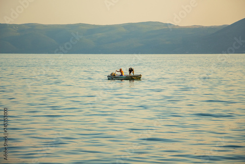 Fishermen on a boat in the sea catch fish