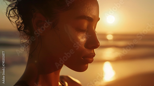 Mulher praticando yoga na praia ao pôr do sol com luz suave e o sol dourado ao fundo photo