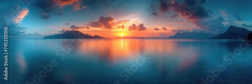 Bright sunset over calm sea and distant mountains