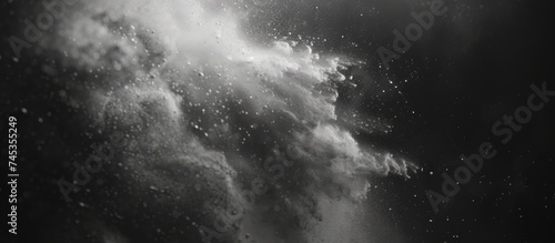 A large wave in black and white, crashing forcefully with visible foam and spray. The wave appears powerful and dynamic, showcasing natures raw energy.