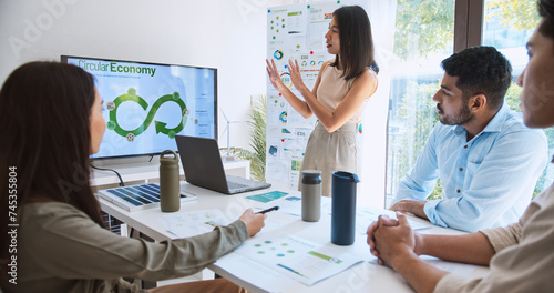Asian woman lead young group of multiethnic businesspeople in team meeting, using laptop computer for ESG topic presentation on monitor. Sustainable business practice, people work at home concept