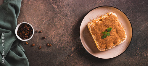 Tiramisu cake made of cookies, delicate cream and coffee on a plate top view web banner