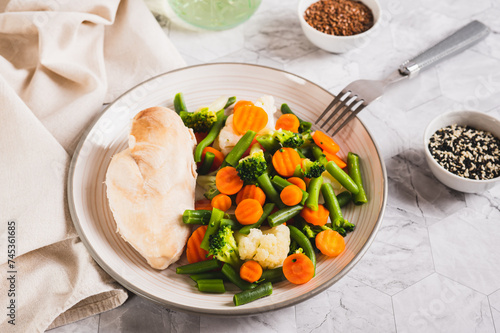 Boiled assorted vegetables and chicken fillet for diet food on a plate photo