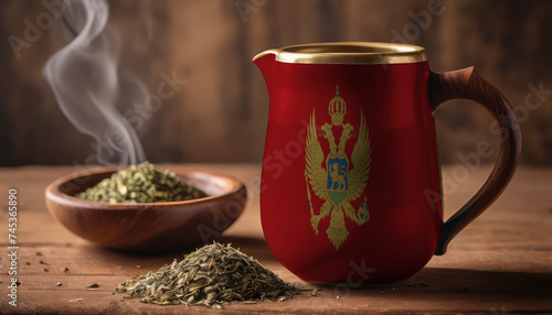 A teapot with the Montenegro flag printed on it is on the table, next to it is a mug of tea and green tea is scattered. Concept of tea business, friendship, partnership