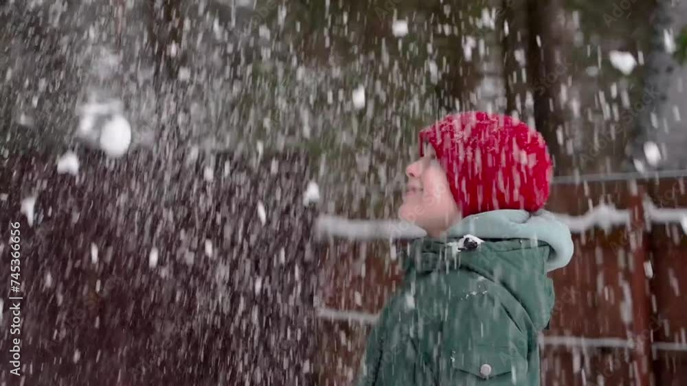 Young boy playing with snow and smiling