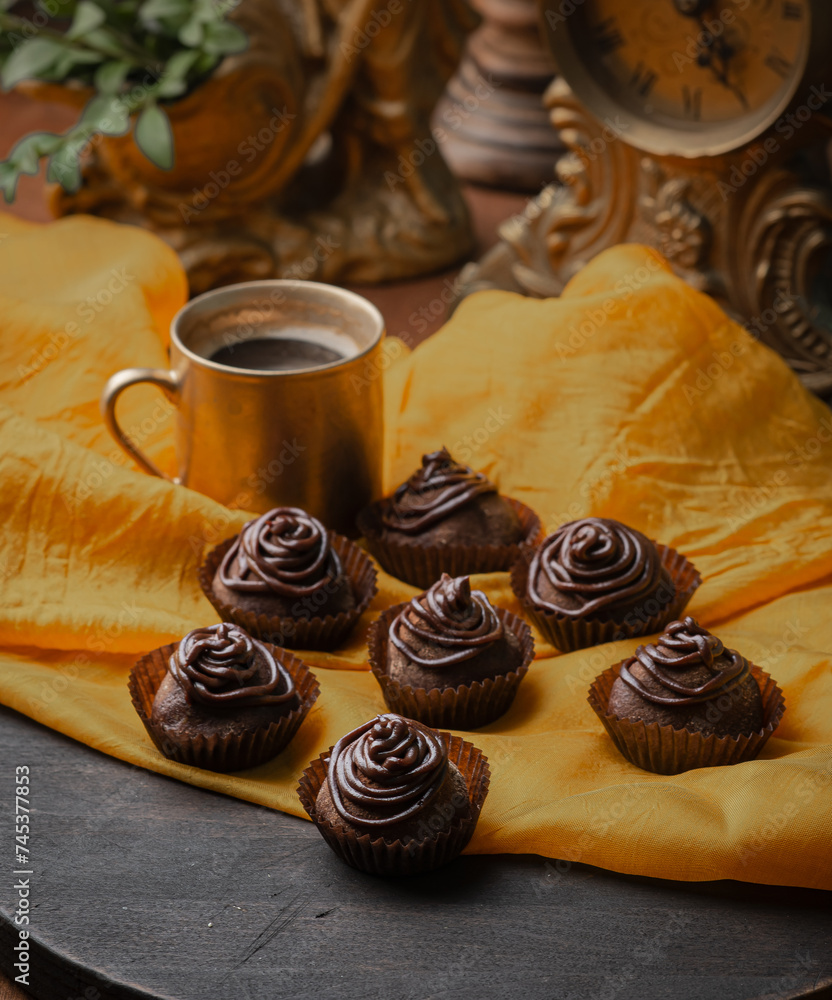 Handmade chocolates on a background of a golden tablecloth with a cup of coffee Handmade chocolates on a background of a golden tablecloth with a cup of coffee