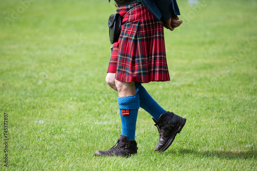 A Scottish Highland Games judge walks around the field wearing a red kilt in the town of Crieff photo