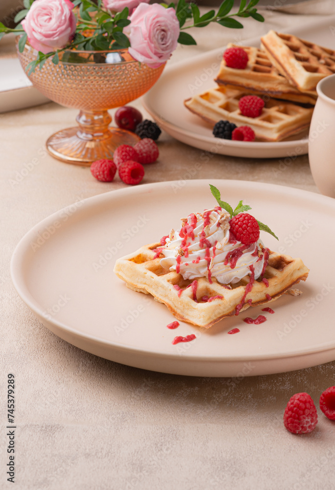 Viennese waffles with berry sauce and cream on a light background Viennese waffles with berry sauce and cream on a light background