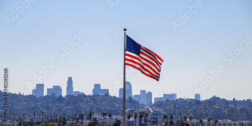 USA Flag flying with Los Angeles skyline in background