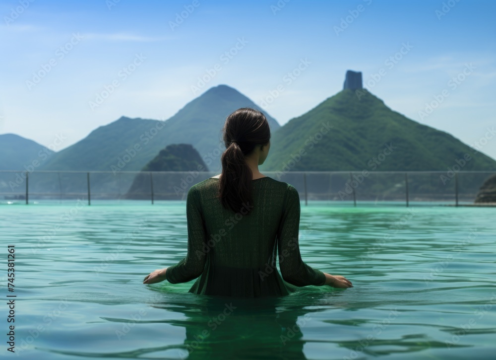 Woman relaxing in the waters overlooking a skyline at dusk.