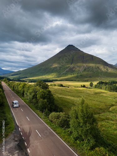 Aerial view of the A82 road as it passes through Bridge of Orchy with the mountains. Highlands Scotland