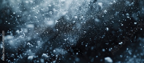 Snowflakes gracefully falling on a black and white canvas, resembling abstract water splashes. The contrast between the dark background and the motionless white particles creates a tranquil winter