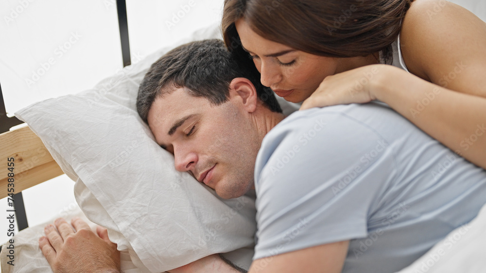 Beautiful couple lying on bed kissing while sleep at bedroom Beautiful couple lying on bed kissing while sleep at bedroom