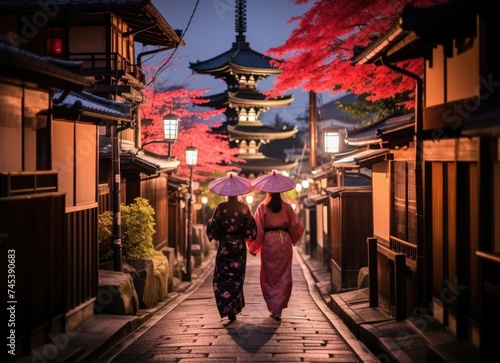 Evening stroll by a pagoda: two women in kimonos walking through kyotos alleys. © Marharyta