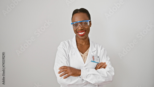 Smiling african american woman scientist, standing confidently with crossed arms - a beautiful portrait isolated on a white background © Krakenimages.com