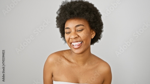 Portrait of a joyful african american woman with curly hair against an isolated white background, beaming with happiness