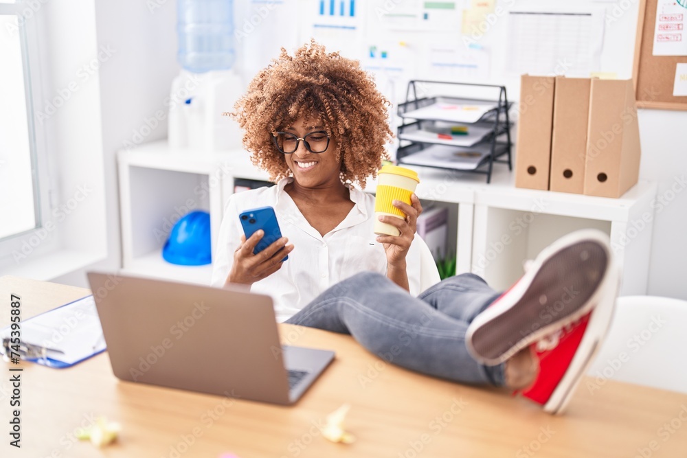 African american woman business worker using smartphone drinking coffee at office African american woman business worker using smartphone drinking coffee at office