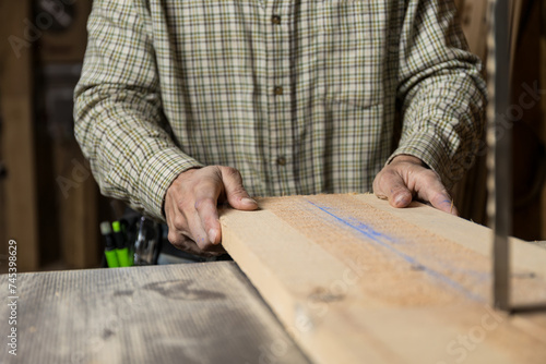 Horizontal photo artisan carpenter using bandsaw in workshop.Copy space. Business concept.