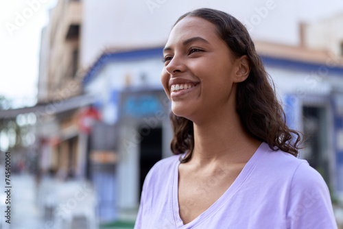 Young african american woman smiling confident looking to the side at coffee shop terrace