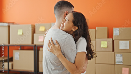 Fotografía Two smiling workers, man and woman, sharing a heartfelt hug in the office, embod